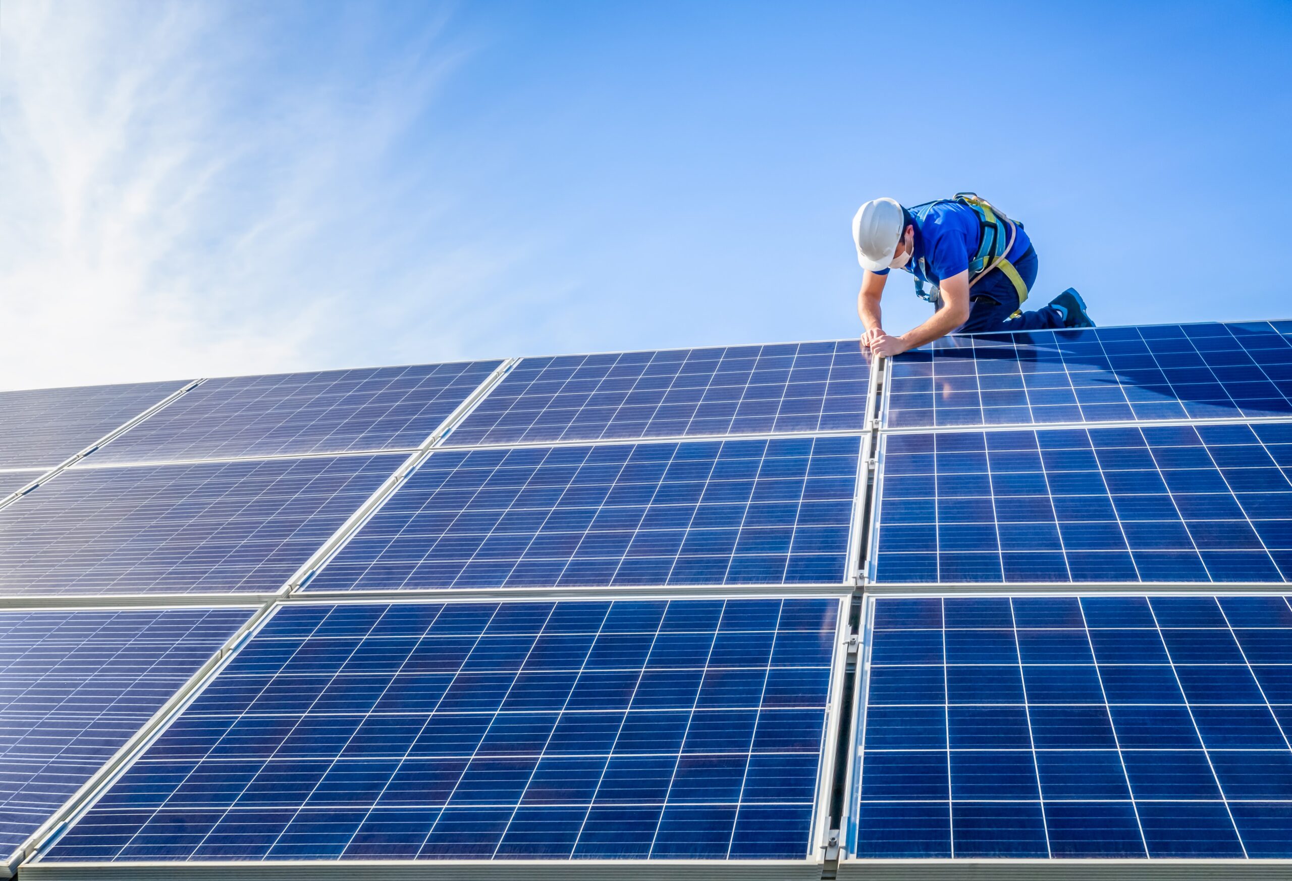 An engineer fitting solar panels on a roof